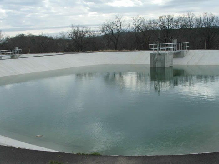 Circular concrete water treatment basin filled with water