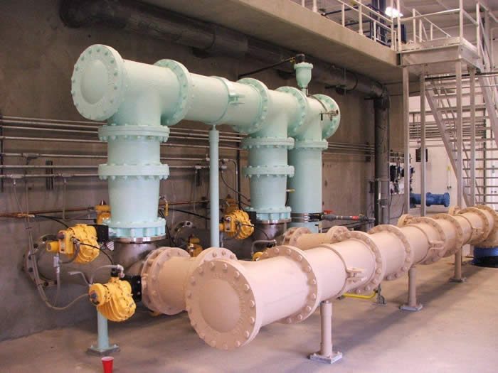 Interior mechanical room with blue and green process piping and pumps